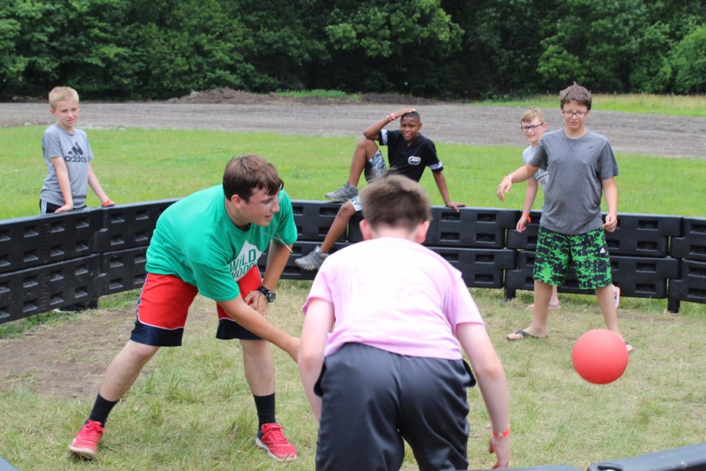 Campers and a counselor playing Gaga ball. 