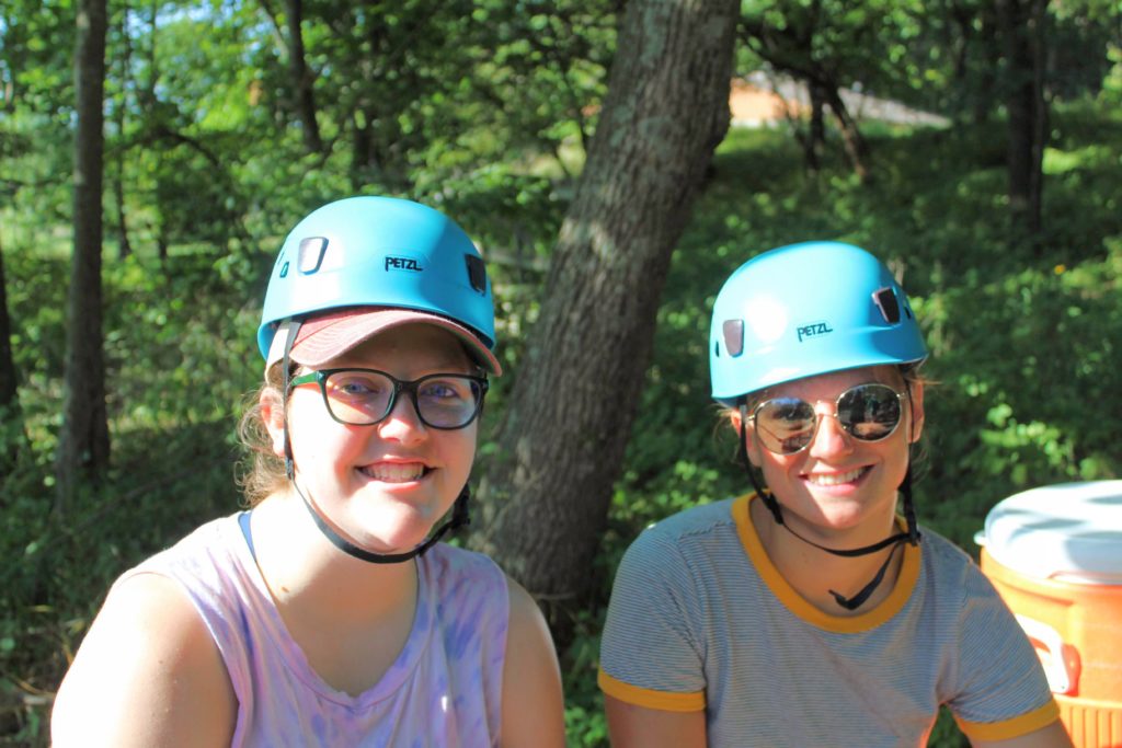 two camp counselors training on high ropes